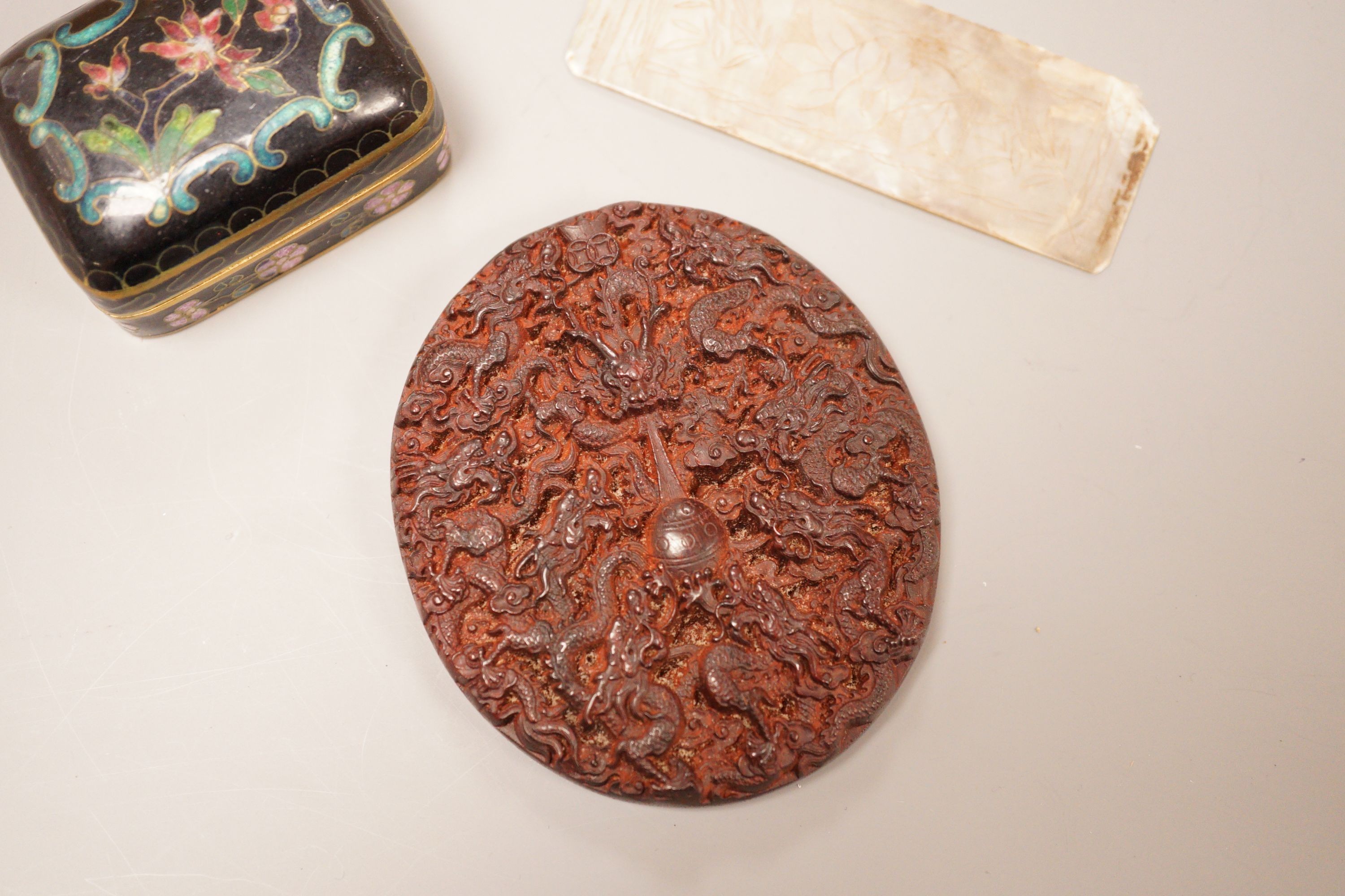 A Chinese cloisonne box, a lacquer carving and a mother of pearl counter